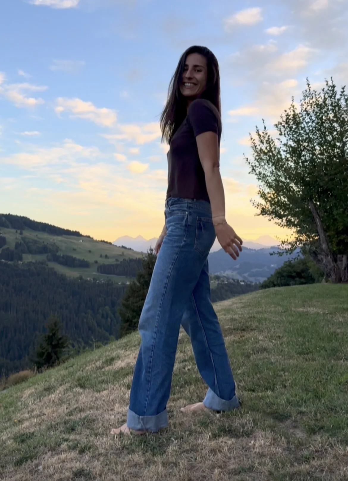 Marie Lamy souriante en extérieur, dans un paysage de montagne.